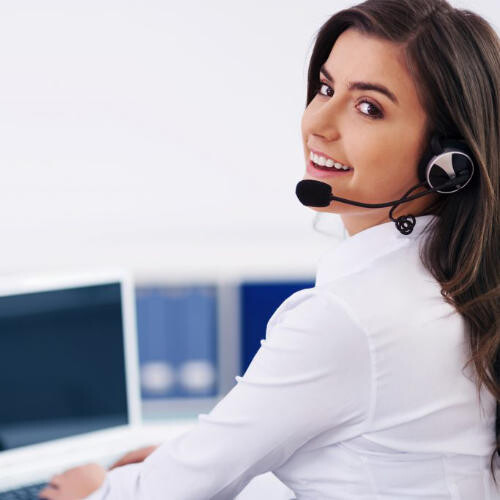 Auf diesem Bild ist eine weibliche Person zu sehen, die ein Headset aufhat und an einem Computer sitzt. Dieses Bild soll den Kundenservice und die Beratung von KWS-Tools darstellen.